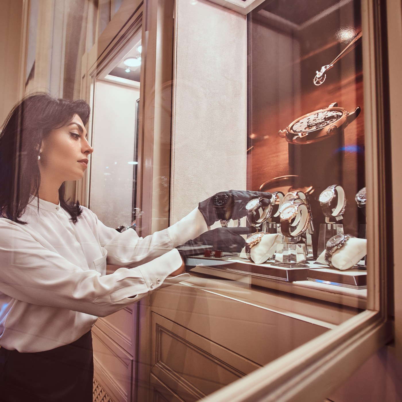 Conseillère présentant des montres de luxe dans une vitrine d'exposition